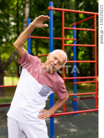 Senior man doing warming up exercises 138120221
