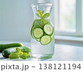 Refreshing detox water with cucumber slices and fresh mint in a glass carafe on a bright morning background. 138121194
