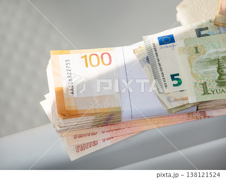 Pile of assorted international banknotes and a stack of paper currency. Concept of global wealth, currency exchange, economy, savings, finance and international business trade market. 138121524