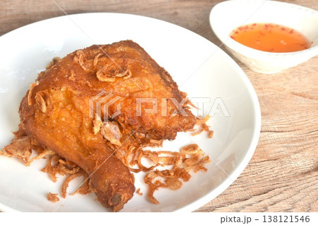 crispy chop fried chicken tight and leg with shallot on plate dipping sweet chili sauce in cup crispy chop fried chicken tight and leg with shallot on plate dipping sweet chili sauce in cup 138121546