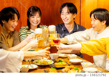 居酒屋で乾杯をする若い男女 居酒屋で乾杯をする若い男女 138121792