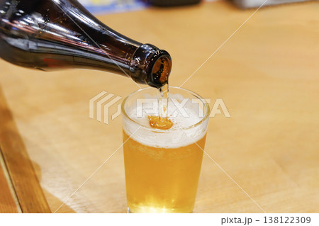 瓶ビールからグラスへ注がれる黄金色のビール 瓶ビールからグラスへ注がれる黄金色のビール 138122309