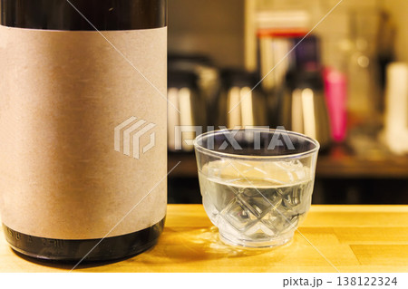 グラスに注がれた日本酒とボトルの背景 138122324