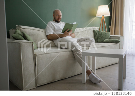 Portrait of man reading a book at home Portrait of man reading a book at home 138123140