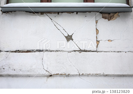 Cracked Plaster Facade With Structural Damage Beneath Window Overhang 138123820