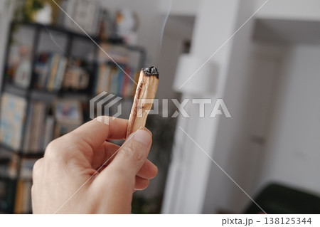 a man scents a room with sandalwood smoke 138125344
