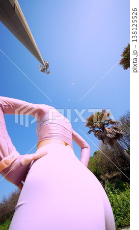 Person in pink bodysuit flawlessly aligns spine during outdoor yoga session Person in pink bodysuit flawlessly aligns spine during outdoor yoga session 138125526