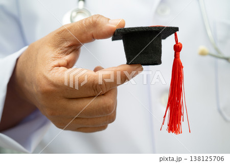 Asian woman doctor holding graduation hat in hospital, Medical education. Asian woman doctor holding graduation hat in hospital, Medical education. 138125706