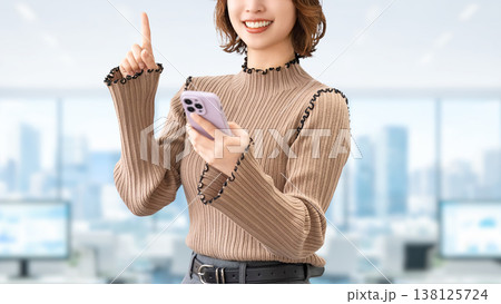 スマートフォンを持って案内をする笑顔の女性・ビジネスウーマン 138125724