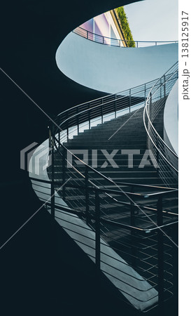 Modern curved staircase with metal railing in minimalist interior architecture, Contemporary concrete stairs with smooth lines and clean design in modern building 4k 138125917