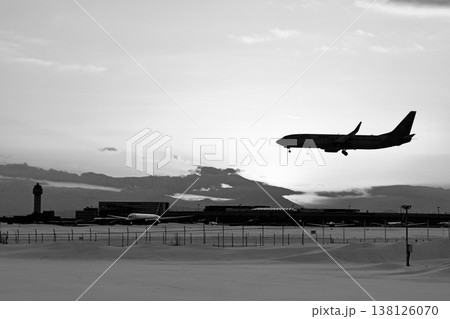 「冬の新千歳空港」夕焼けをバックに着陸する機影「白黒」 「冬の新千歳空港」夕焼けをバックに着陸する機影「白黒」 138126070