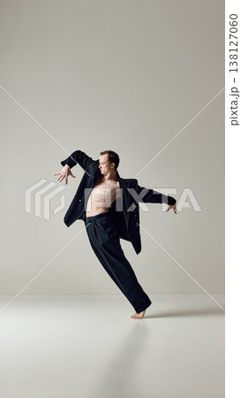 Male dancer leaning in fluid motion with open suit in studio. Male dancer leaning in fluid motion with open suit in studio. 138127060