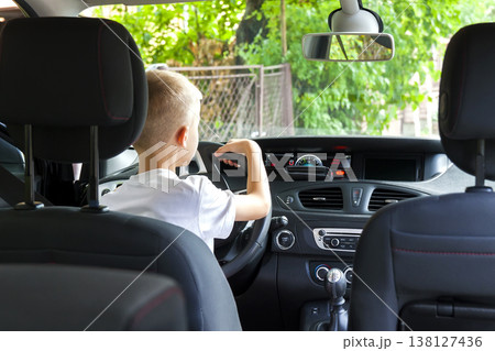Little child boy behind the steering wheel of a car 138127436