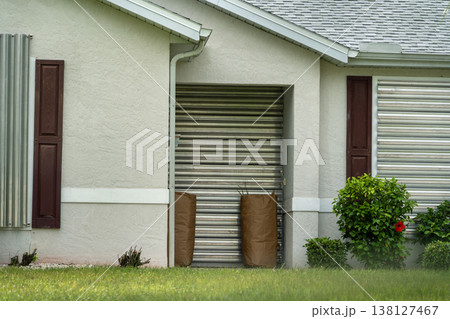Hurricane shutters on Florida house windows. Home protection before natural disaster Hurricane shutters on Florida house windows. Home protection before natural disaster 138127467