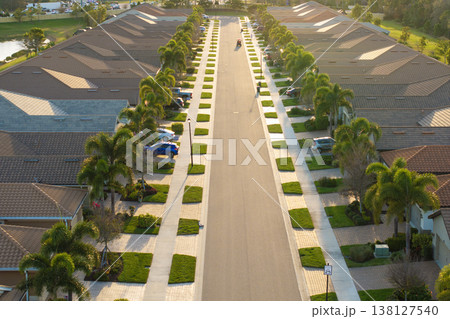 Gated community with expensive houses between green palm trees in southwest Florida. Premium housing development in the USA Gated community with expensive houses between green palm trees in southwest Florida. Premium housing development in the USA 138127540