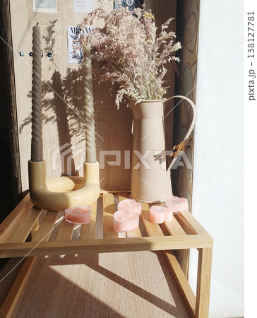 Romantic home decor with pink heart-shaped candles, twisted candles in a ceramic holder, and pampas grass Romantic home decor with pink heart-shaped candles, twisted candles in a ceramic holder, and pampas grass 138127781