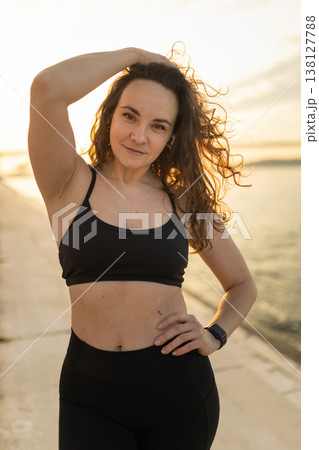 Woman posing outdoors wearing athletic sportswear at sunset Woman posing outdoors wearing athletic sportswear at sunset 138127788