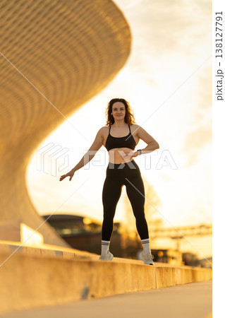 Woman exercising outdoors embracing urban fitness at sunset Woman exercising outdoors embracing urban fitness at sunset 138127791