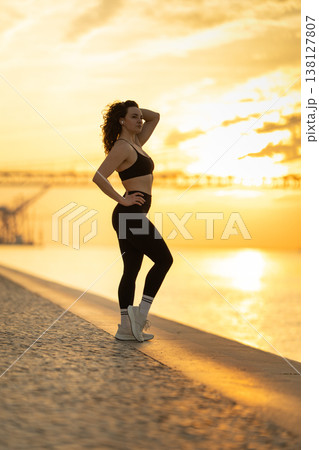 Woman in sportswear posing during golden hour sunset 138127807