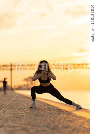 Woman exercising lunge during fitness workout at sunrise Woman exercising lunge during fitness workout at sunrise 138127814