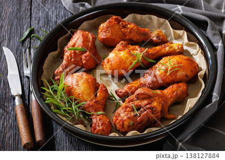 Roasted chicken drumsticks on paper in baking dish 138127884