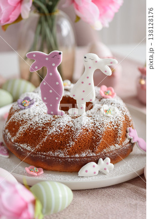 Traditional easter cakes with icing decorated with gingerbread cookies in shape of rabbits on white wooden table Traditional easter cakes with icing decorated with gingerbread cookies in shape of rabbits on white wooden table 138128176