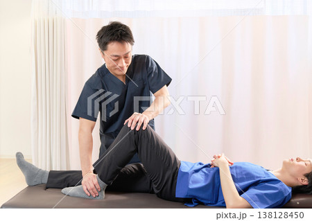 整体院で脚のストレッチ施術を行う整体師 138128450