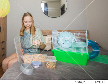 A woman holds a yellow ball while a girl organizes bedding insid 138129115
