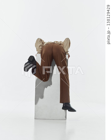 Person leaning forward over white pedestal in studio isolated on white background. 138129429
