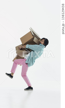Man struggling to hold multiple cardboard boxes and losing balance in studio isolated on white background 138129438