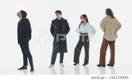 Group of stylish people standing apart and looking in different directions in studio. Group of stylish people standing apart and looking in different directions in studio. 138129465