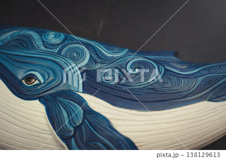 Extreme close-up of a wooden whale sculpture focusing on the eye and ornate blue carved patterns. Extreme close-up of a wooden whale sculpture focusing on the eye and ornate blue carved patterns. 138129613