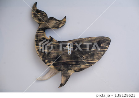 Back view of a hand-carved wooden whale sculpture, showing natural scorched wood grain and a metal mounting bracket. Back view of a hand-carved wooden whale sculpture, showing natural scorched wood grain and a metal mounting bracket. 138129623