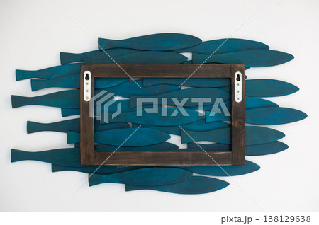 Rear view of a wooden fish wall art panel showing the mounting frame and turquoise blue fish elements. Rear view of a wooden fish wall art panel showing the mounting frame and turquoise blue fish elements. 138129638