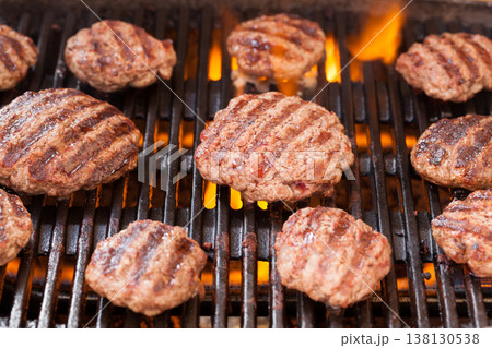 Burger patties grilling with fire and smoke 138130538