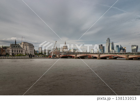 A sweeping vista of the River Thames reveals a grand architectural tapestry, where the historic dome of St. Paul's Cathedral stands in timeless repose amidst the sleek, glass-clad silhouettes of the 138131013