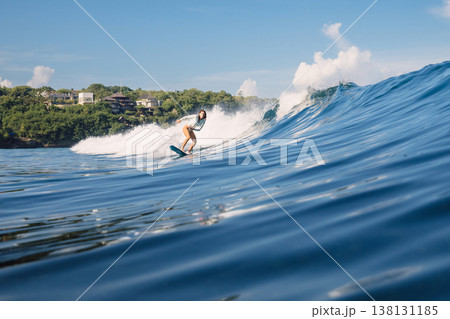 Surfer girl riding on ocean wave in sunny day in Bali Surfer girl riding on ocean wave in sunny day in Bali 138131185