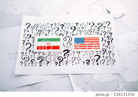 Cards with flags of IRAN and USA lie on paper with question marks over geographic maps. USA Iran relations, regional security, reopen the Strait of Hormuz, Proxy wars, trade disputes. 138131350