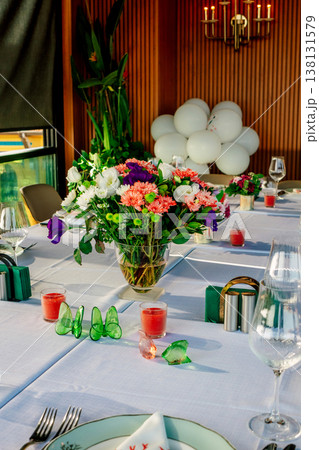 Elegant Table Setting With Floral Centerpiece, Pastel Balloons, Candlelight Chandelier, White Linen Elegant Table Setting With Floral Centerpiece, Pastel Balloons, Candlelight Chandelier, White Linen 138131579