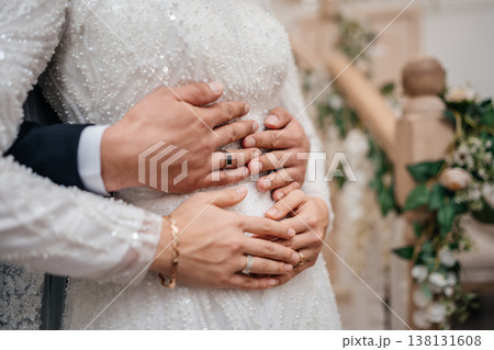 Closeup Hands Of Newlyweds Embracing With Rings And Beaded Gown, Soft Light, Floral Staircase Decor 138131608