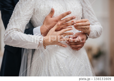 Tender Hands Intertwined Over Sequin Gown With Rings And Floral Background, Gentle Support . Tender Hands Intertwined Over Sequin Gown With Rings And Floral Background, Gentle Support . 138131609