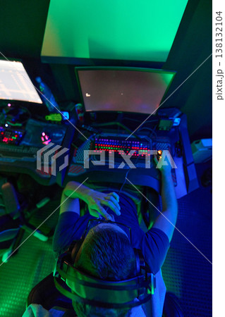 Overhead View Of Gamer Playing At Neon-Lit PC Station With Headset And Mechanical Keyboard 138132104