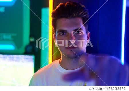 Young Man Portrait in Neon Gaming Room With Futuristic Blue and Green Lighting 138132321