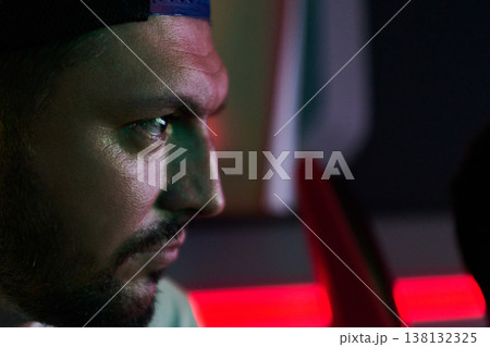 Focused Young Man Profile Portrait With Neon Lighting Concentrating in Low Light Environment Focused Young Man Profile Portrait With Neon Lighting Concentrating in Low Light Environment 138132325
