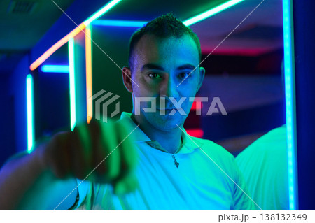 Neon Portrait Of Young Man Reaching Forward In Colorful Club Lighting 138132349