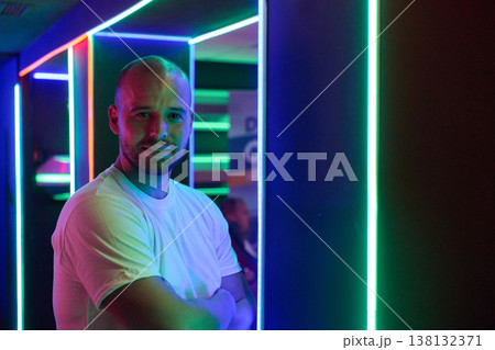 Confident Man Portrait in Neon Lights at Nightclub With Arms Crossed and Casual White T Shirt 138132371