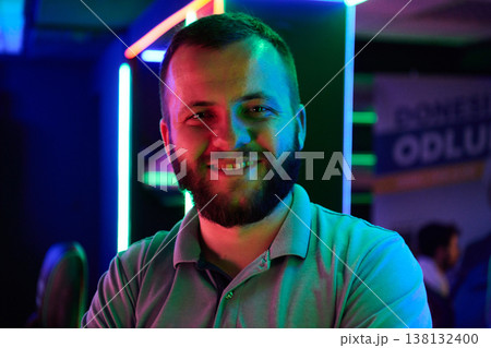Smiling Bearded Man Portrait in Neon Lights at Nightclub or Gaming Lounge 138132400