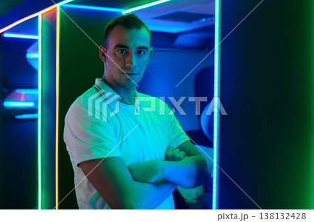 Confident Young Man Portrait in Neon Gaming Room With LED Lights and Arms Crossed Confident Young Man Portrait in Neon Gaming Room With LED Lights and Arms Crossed 138132428