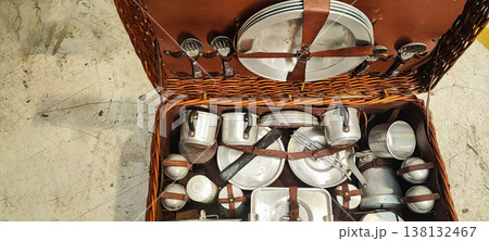 A vintage picnic suitcase with neatly arranged metal plates, cups, and cutlery. It encompasses concepts of retro lifestyle, outdoor recreation, eco-friendliness, and nostalgic travel. A vintage picnic suitcase with neatly arranged metal plates, cups, and cutlery. It encompasses concepts of retro lifestyle, outdoor recreation, eco-friendliness, and nostalgic travel. 138132467