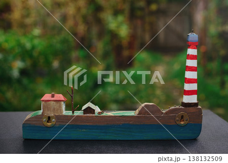 Horizontal back view of a handcrafted wooden wall-mounted key holder with a lighthouse diorama, showing the mounting brackets. Horizontal back view of a handcrafted wooden wall-mounted key holder with a lighthouse diorama, showing the mounting brackets. 138132509